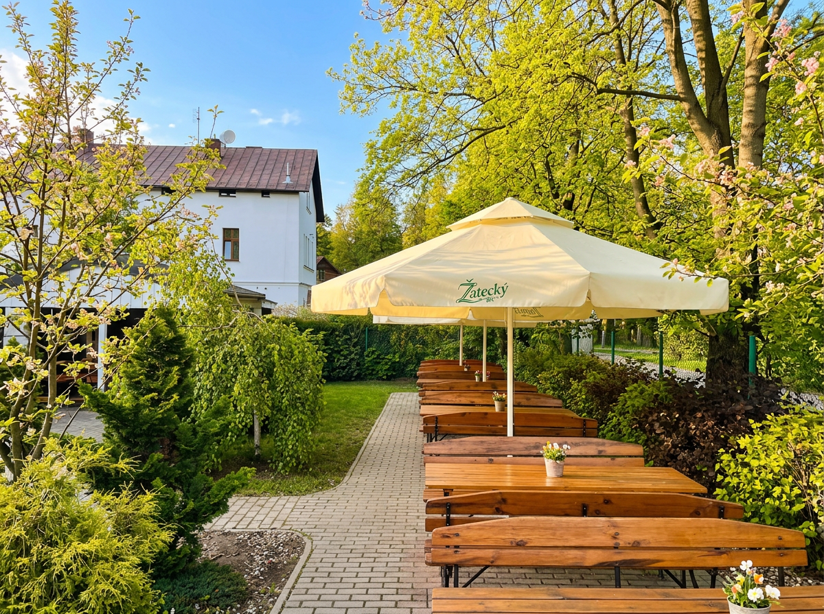 Ogród Restauracji Zdrojowa z drewnianymi ławami i parasolem